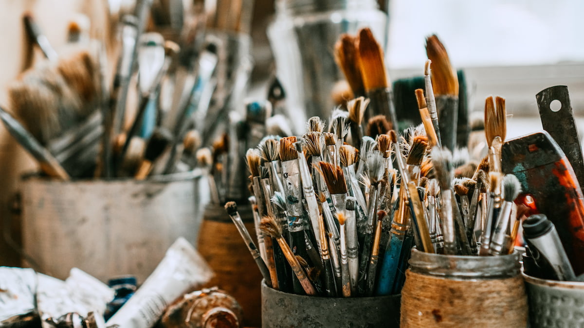 Table with brushes and tools in art workshop. Background.